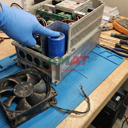 Kỹ thuật viên kiểm tra tụ điện và quạt làm mát bên trong biến tần